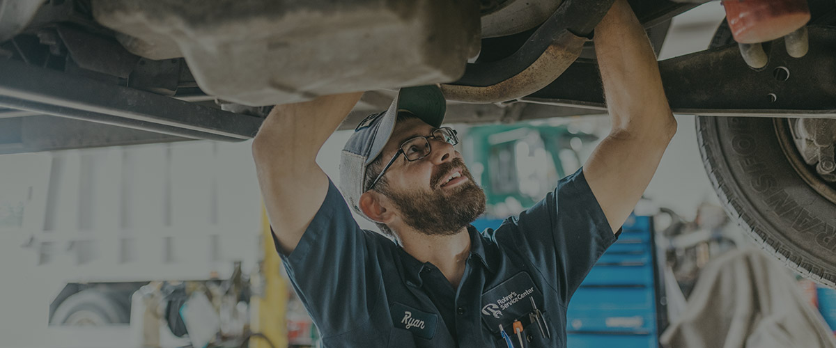 Mechanic working below truck