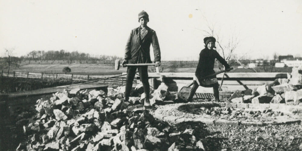 An old photograph of a man and a woman quarrying rock by hand in 1886