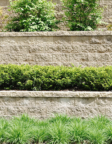 Three levels of retaining walls made from landscaping blocks for a polished finish for shrubs