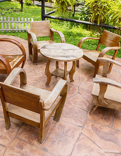 marbled, clay red concrete that has been stamped to look like tile for a patio with chairs around a table